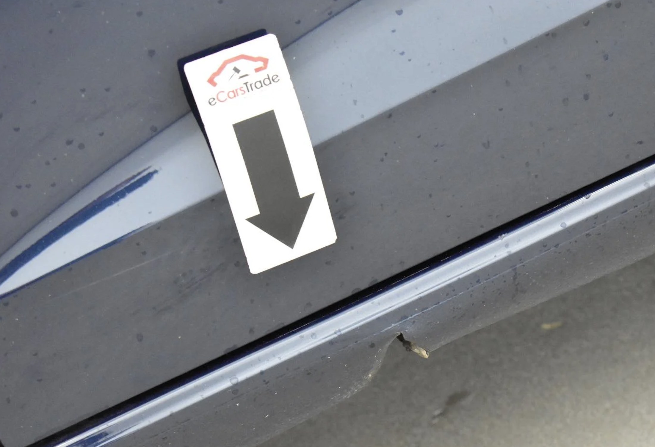 eCarsTrade kinyomtatott nyíl, amely egy kisebb autó sérülésére mutat