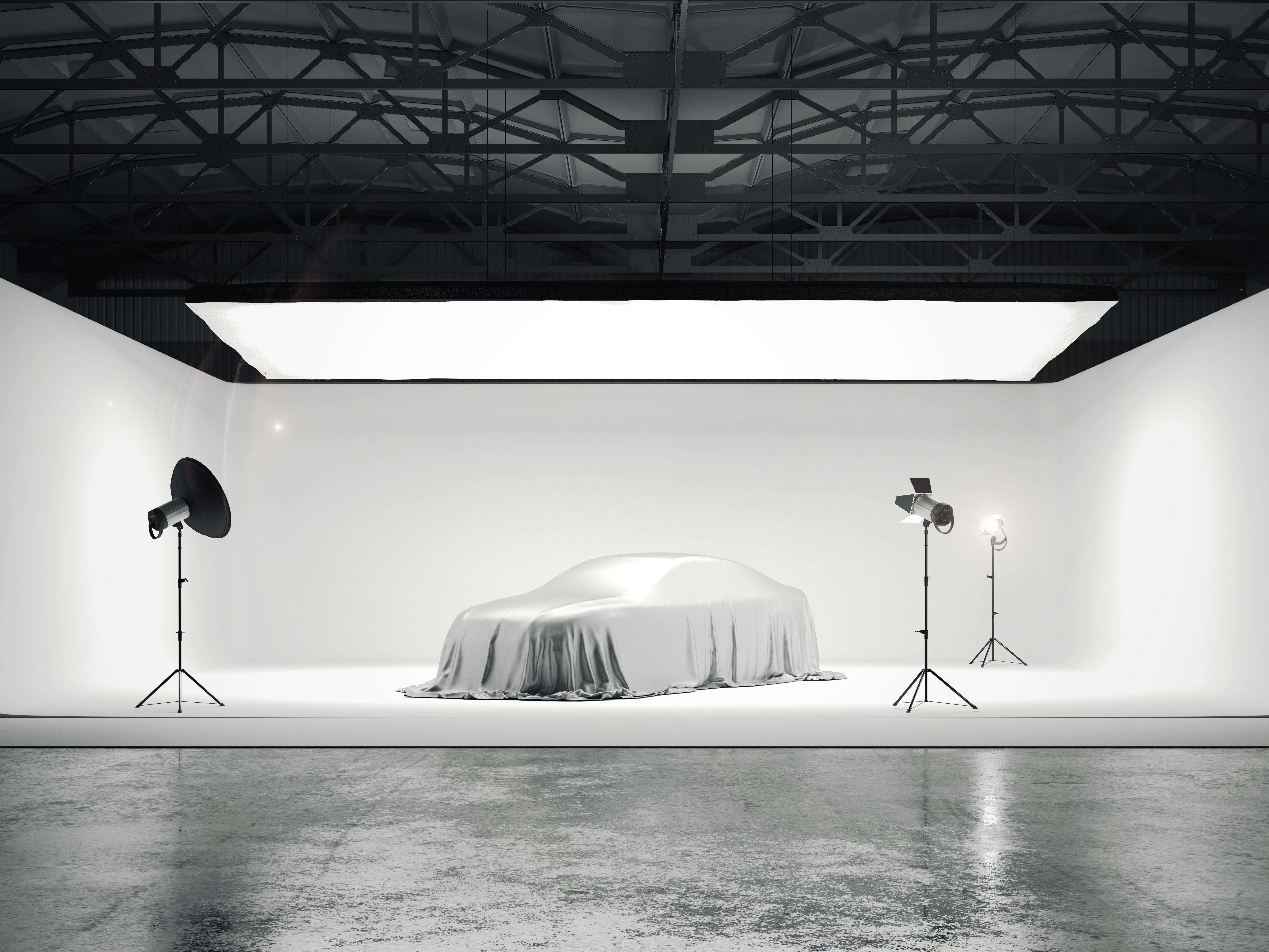 Nagyméretű fotóstúdió egy autóval és több fényforrással